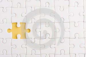 Top view flat lay of paper plain white jigsaw puzzle game texture incomplete or missing piece, studio shot on a yellow background