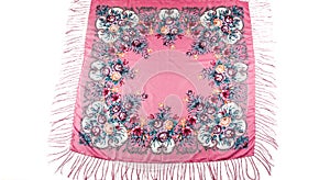 Top view flat lay on pink cotton scarf with fringe and bright floral ornament