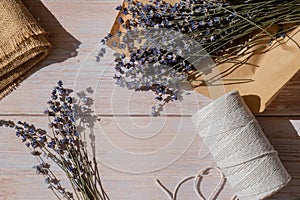 Top view flat lay of process making bouquets of dried lavender flowers. Cotton rope, scissors. Female do homemade herbs