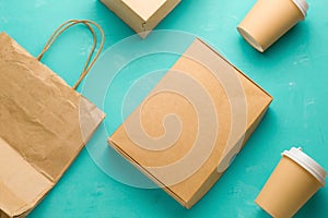 flat lay recyclable types of paper packaging on a blue background, paper bag, disposable glass, cardboard box