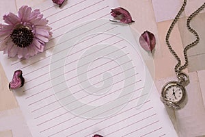 Top view flat lay shot of letter paper envelope and flower petals pocket watch