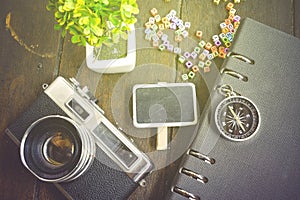 top view flat lay vintage camera, compass, plant and signage on wooden background