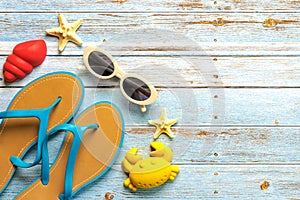 Top view of flip flops,sunglasses, starfish and beach toys with copy space for text. Summer holiday concept