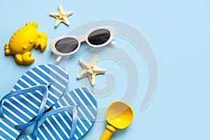 Top view of flip flops,sunglasses, starfish and beach toys with copy space for text. Summer holiday concept
