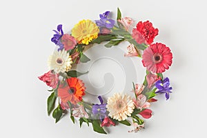 top view of floral wreath made of beautiful colorful flowers and green leaves on grey