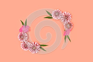 Top view of flower border frame made of dahlia on a coral color background.