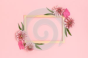 Top view of flower border frame made of dahlia on a pink background