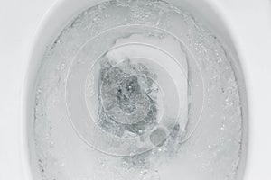 Top view, flushing water in the toilet close-up.