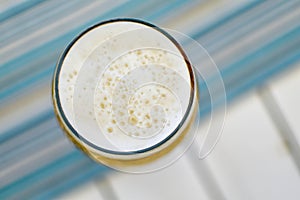Top view of a foamy mug of cold beer on a hot summer day in a re