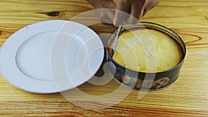 Top view focus out from round homemade flan in metal baking dish on wooden table