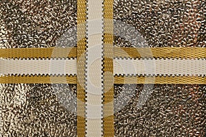 Top view of foil gift box tied with golden ribbon background