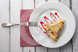 Top view of folded pancake on white plate