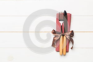Top view of fork and knife on napkin on wooden background. Different christmas decorations and toys. New Year dinner concept with