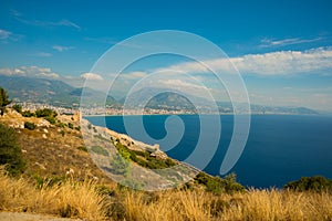 Top view from the fortress of Alanya on the blue sea, the fortifications and the city. Alanya, Antalya district, Turkey, Asia