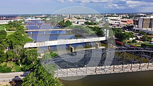 Top view four bridges including vehicular, Railway and Suspension Bridge cross the Brazos River in downtown Waco, Texas