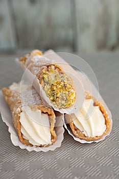 Top view of four delicious cannoli on wooden background