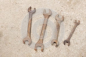 Top view  four old rusted spanner wrenches Mechanic tool on grey concrete background