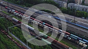 Top view of freight trains on railway tracks on background of houses. Footage. Import and export of freight transit by