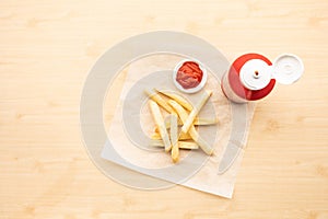 Top view of french fried with tomato sauce  ketchup  on wood table background.Fast food and unhealthy eating concepts