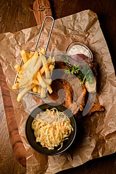 top view of french fries and bowl of sauerkraut and delicious batter fried pork ears