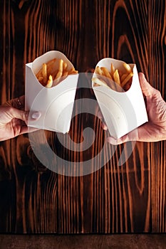 Top view of French fries. The concept of fast food, quick bites and restaurants for catering. Potatoes in carton and ketchup.