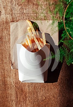 Top view of French fries. The concept of fast food, quick bites and restaurants for catering. Potatoes in carton and ketchup.
