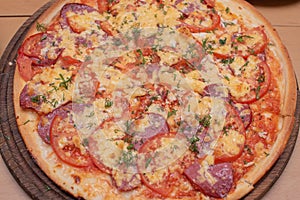 Top view of fresh baked pizza. Pizza on a wooden plate