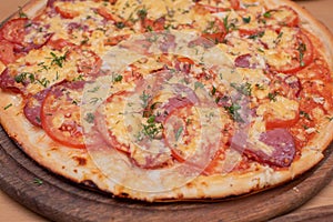 Top view of fresh baked pizza. Pizza on a wooden plate