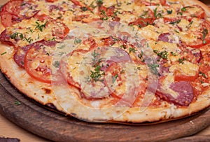 Top view of fresh baked pizza. Pizza on a wooden plate