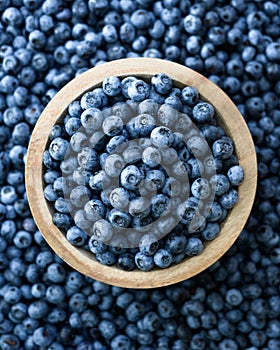 Top view of fresh blueberries in a wooden plate