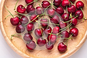 Top view fresh cherry fruit berries in wooden plate on white background