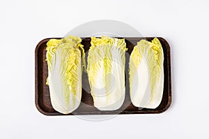 Top view of fresh chinese cabbage â€‹on a wooden tray isolated on white background