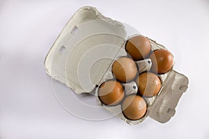 Top view of fresh eggs in grey egg box,on white background, set of six photo
