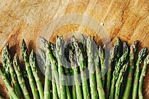 Top view of fresh green asparagus border on vintage wooden table. Cooking vegetarian food with organic ingredient on rustic board