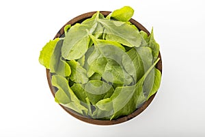 Top View of Fresh Green Spinach Leaves in Wooden Bowl Isolated on White Background