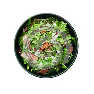 Top view of fresh green vegetable salad with sliced smoked duck and red pomegranate seeds and Parmesan cheese shaved in black bowl