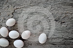 Top view of fresh organic chicken eggs in rustic natural wooden background with copy space.