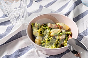 Top view on fresh prepared broccoli with gnocchi in bowl on the table - homemade healthy food in bright light with copy space