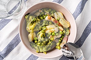 Top view on fresh prepared broccoli with gnocchi in bowl on the table - homemade healthy food in bright light with copy space