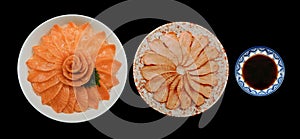 Top view of fresh salmon and grill sashimi and shoyu serve on flower shape in white ice bowl boat isolated on black background, Ja