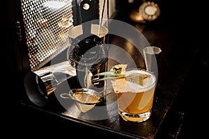 Top view of fresh and sour yellow decorated alcoholic summer cocktail and utensils arranged on the bar table