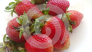 Top view of fresh strawberries in plate on rustic white wood background