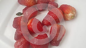 Top view of fresh strawberries in plate on rustic white wood background