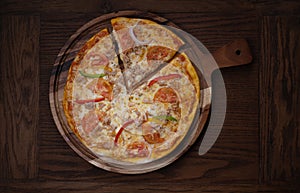 Top view of fresh tasty pizza on wooden background