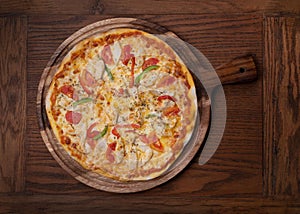 Top view of fresh tasty pizza on wooden background