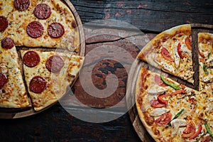 Top view of fresh tasty pizzas on wooden background