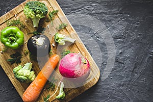 Top view of fresh vegetables on wooden chopping board