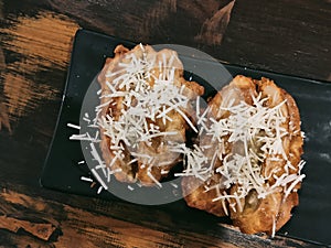 Top view of fried banana with cheese sprinkles