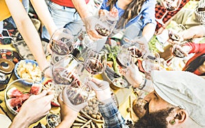 Top view of friend hands toasting red wine glass at barbecue