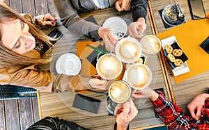 Top view of friends toasting cappuccino at coffee shop restaurant - Millennial students group having fun on breakfast together